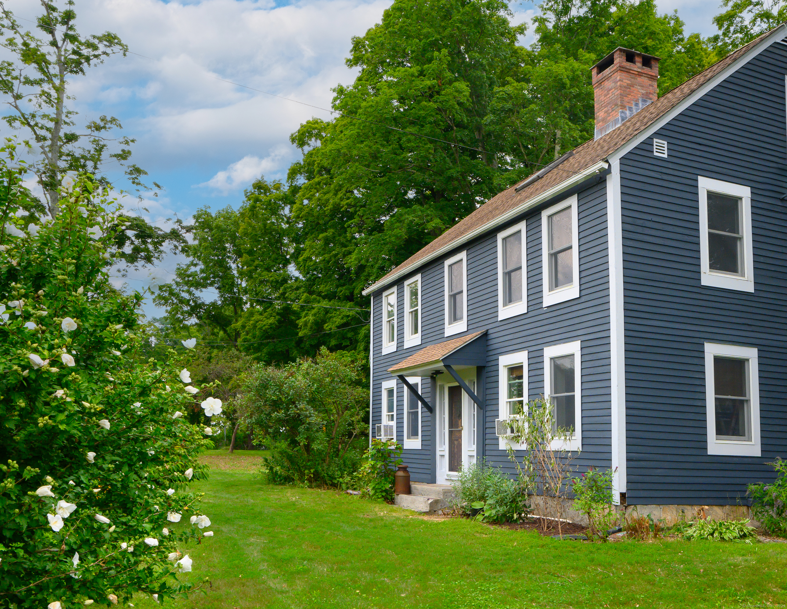 a view of a house with a yard and potted plants