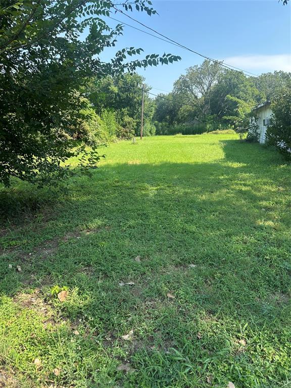 1608 East Walnut Street Waco, TX 76704 - Photo 3 of 4 a view of a grassy field with trees in the background