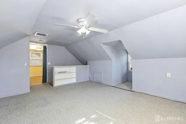 en empty room with windows and ceiling fan