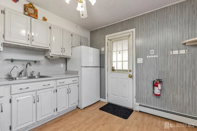 a kitchen with granite countertop white cabinets and refrigerator