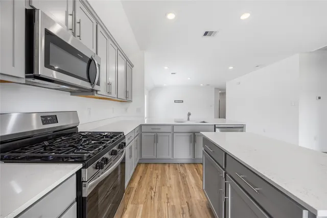 a kitchen with stainless steel appliances granite countertop a sink and stove top oven