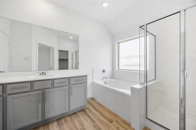 a spacious bathroom with a double vanity sink a mirror and a bathtub