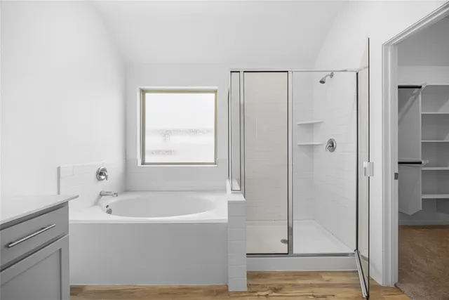 a white bath tub sitting next to a shower