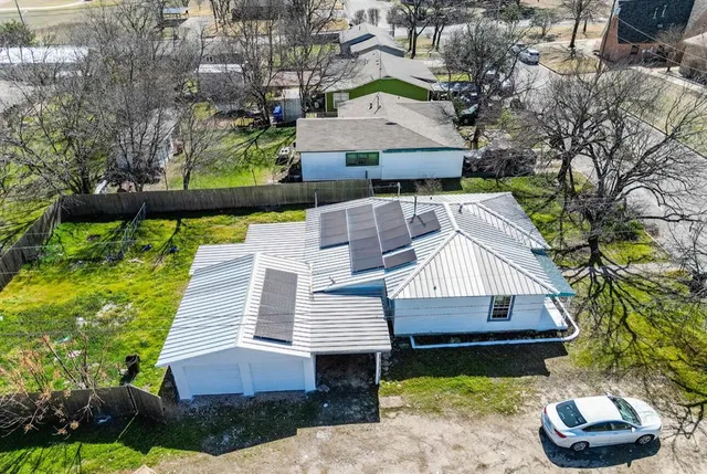 a aerial view of a house with a yard table and chairs