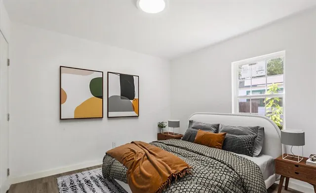 a bedroom with a bed and painting on the wall