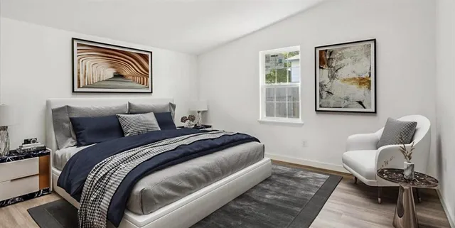 a bedroom with bed and wooden floor