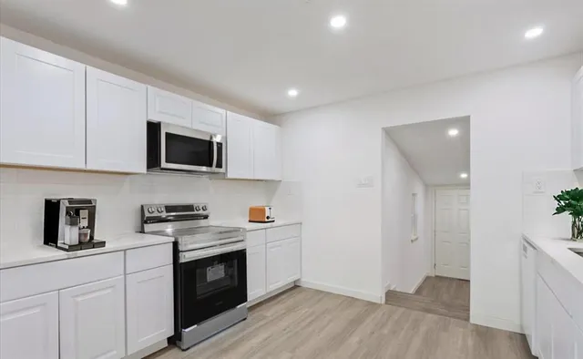 a kitchen with stainless steel appliances granite countertop a sink a stove a microwave and cabinets