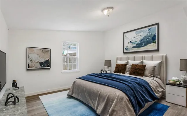 a bedroom with bed and wall painting with wooden floor