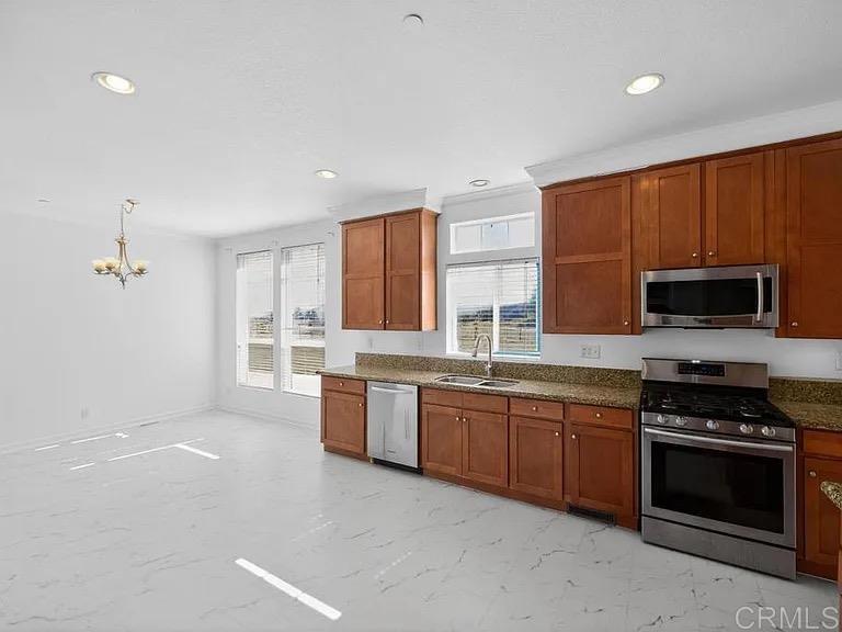 37455 Brandon Road Anza, CA 92539 - Photo 14 of 22 a large kitchen with stainless steel appliances granite countertop a stove a sink dishwasher and a microwave oven with white cabinets