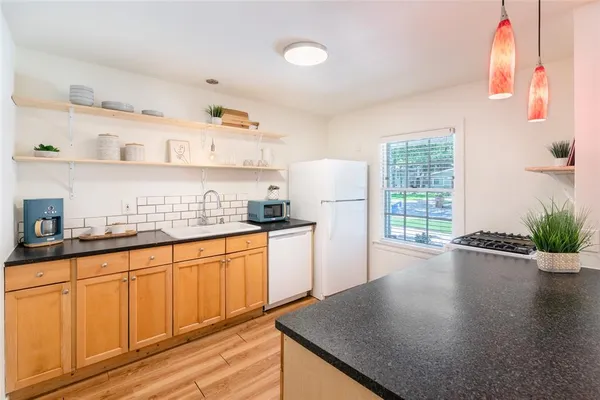 a kitchen with granite countertop stainless steel appliances a sink a counter space and cabinets