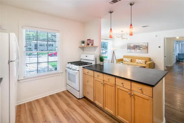 a kitchen with granite countertop white cabinets and white appliances