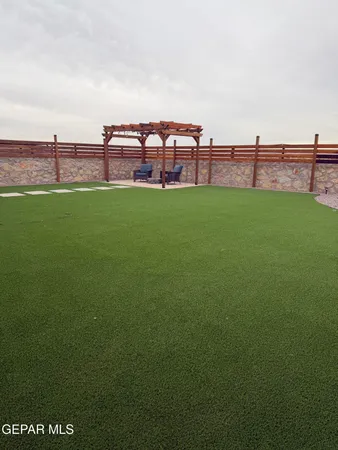 a view of a green field with house in the background