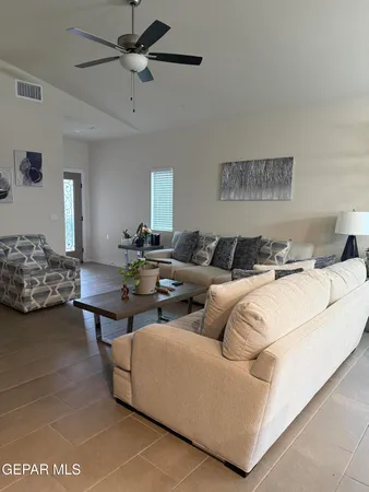 a living room with furniture and a ceiling fan