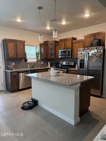 a kitchen with stainless steel appliances granite countertop a sink and a stove