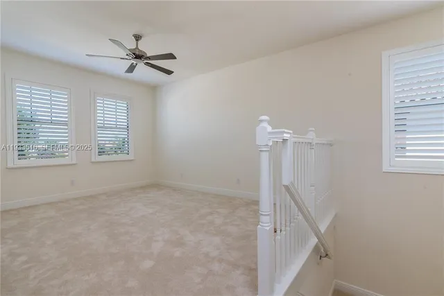 a view of a livingroom with a ceiling fan and window