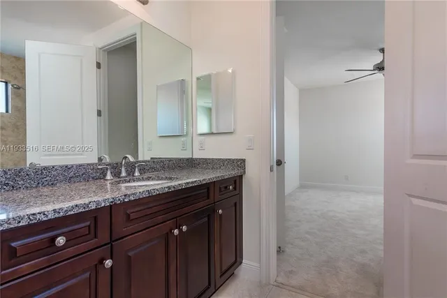 a bathroom with a granite countertop sink and a mirror