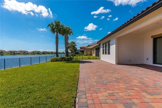 a view of a house with a yard and potted plants