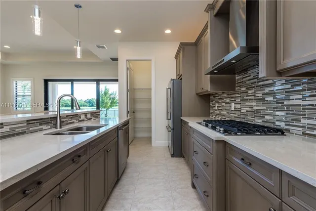 a kitchen with stainless steel appliances granite countertop a sink stove and cabinets