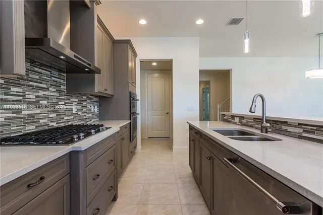 a kitchen with stainless steel appliances granite countertop a sink stove and cabinets