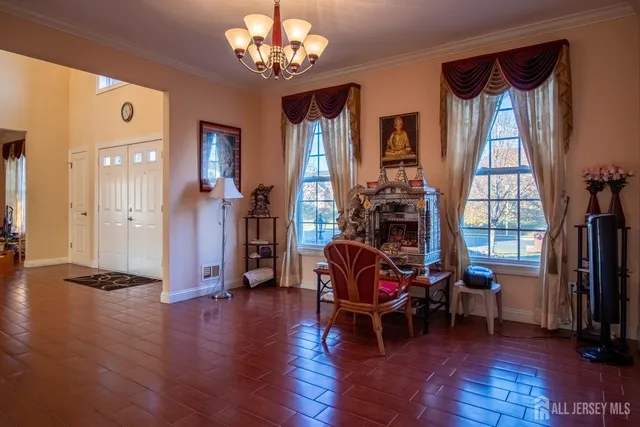 a view of a livingroom with furniture a chandelier and wooden floor