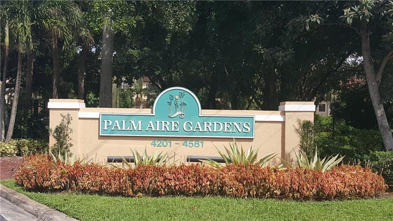a view of sign board with a house in the background