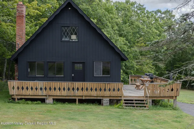a view of a house with a wooden deck and a yard