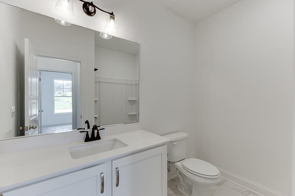 1123 Poppy Lane Jefferson, GA 30549 - Photo 13 of 45 a bathroom with a sink a toilet and mirror