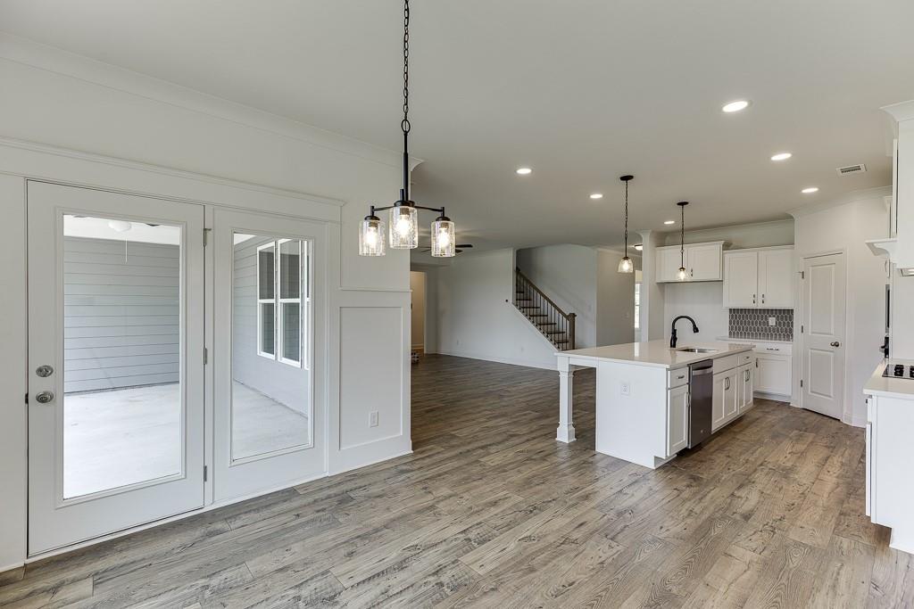 1123 Poppy Lane Jefferson, GA 30549 - Photo 21 of 45 a open kitchen with a refrigerator a sink dishwasher a oven and a dining table with wooden floor