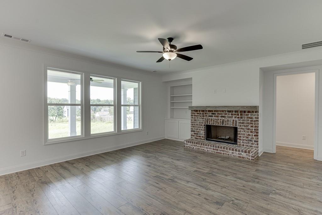 1123 Poppy Lane Jefferson, GA 30549 - Photo 25 of 45 an empty room with wooden floor fireplace and windows