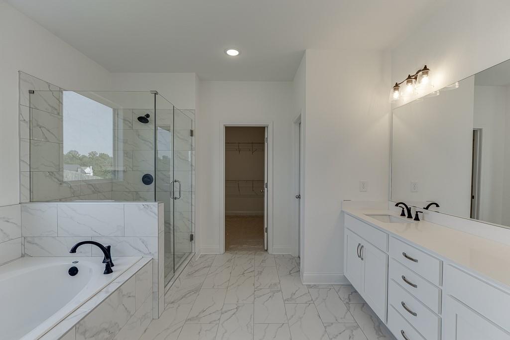 1123 Poppy Lane Jefferson, GA 30549 - Photo 31 of 45 a bathroom with a tub sink double vanity and mirror