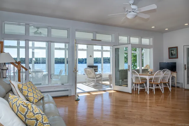 a dining room with furniture water view and wooden floor