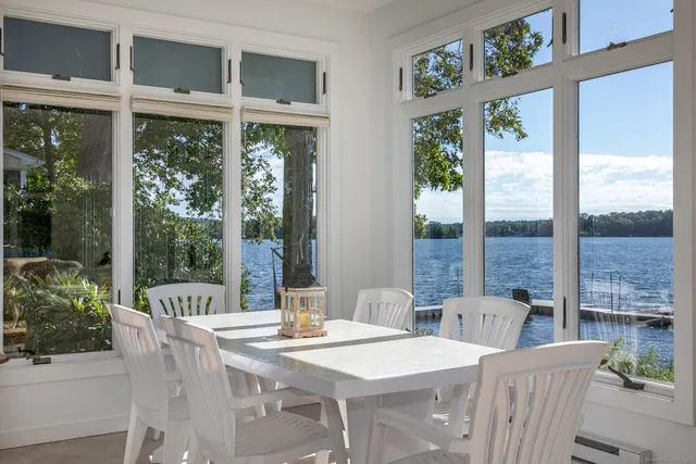 a view of a dining room with furniture large windows and wooden floor