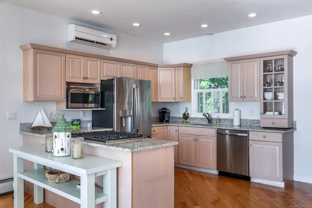 a kitchen with granite countertop a sink stove and refrigerator