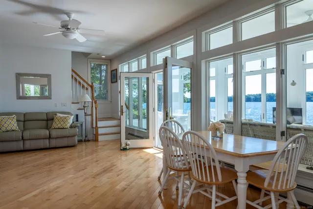 a dining room with furniture a chandelier and wooden floor