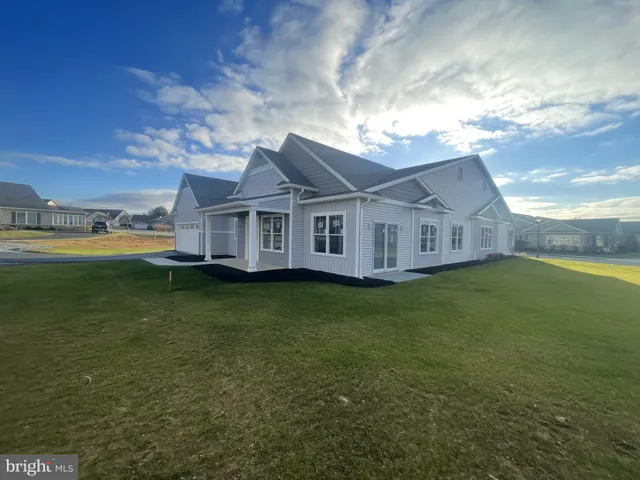 a view of a house with a big yard and large trees