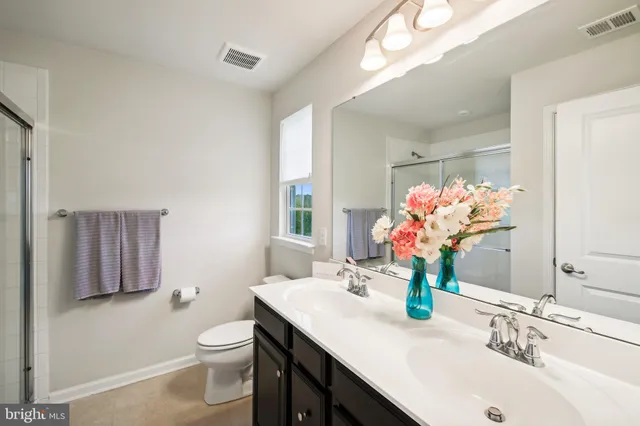 a bathroom with a sink vanity granite and toilet
