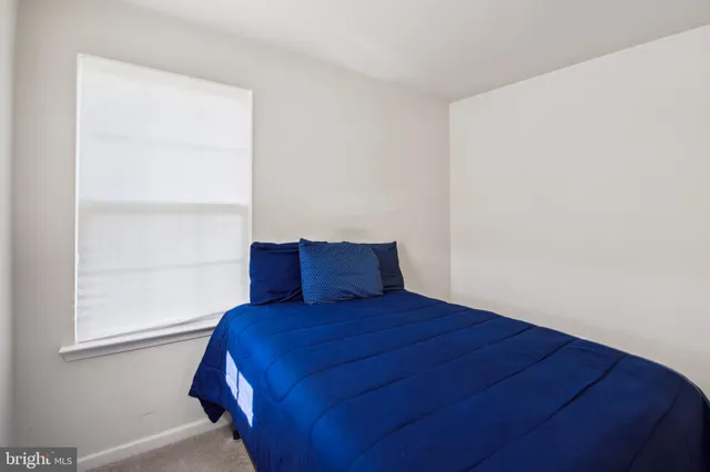 a large bed sitting in a bedroom next to a window