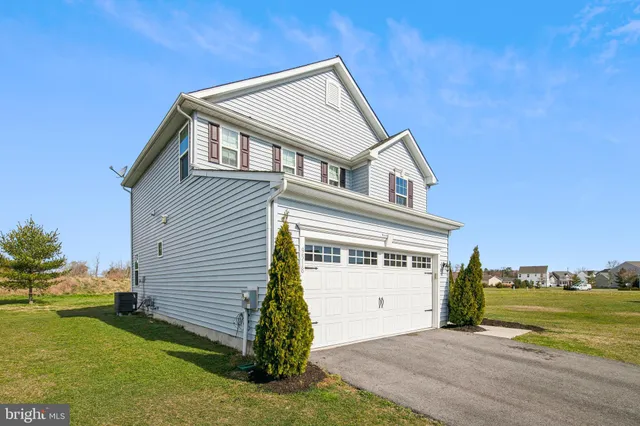 a front view of a house with a yard and ocean view
