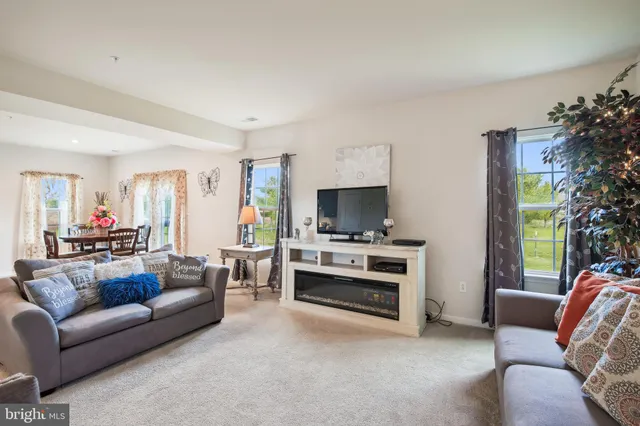 a living room with furniture a flat screen tv and a window