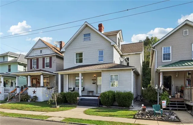 a front view of a house with a yard fire pit and outdoor seating