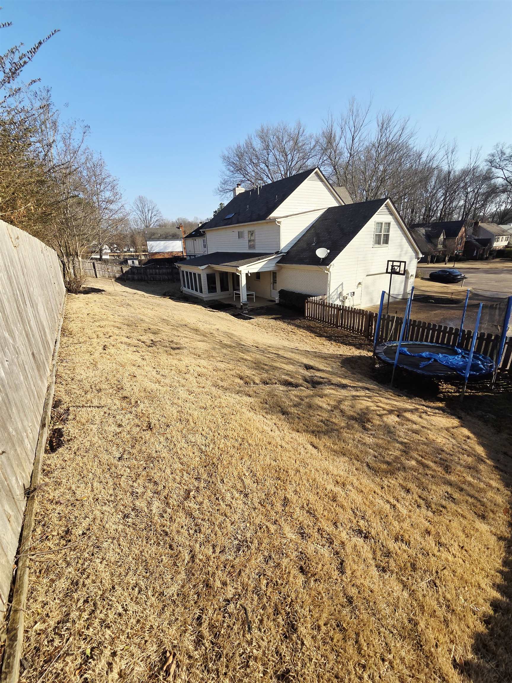2095 Newfields Road Germantown, TN 38139 - Photo 14 of 34 Rear view of property featuring a trampoline, a fenced backyard, and a patio