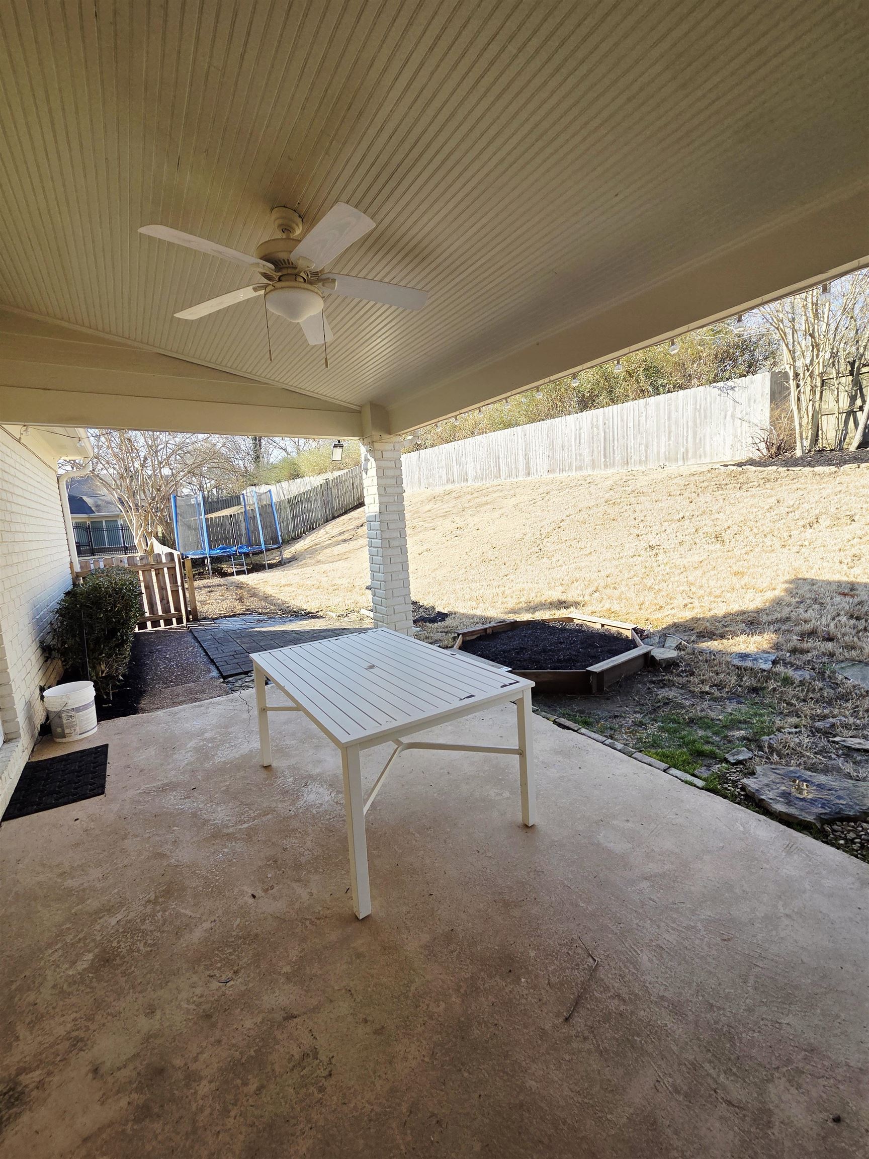 2095 Newfields Road Germantown, TN 38139 - Photo 16 of 34 Fenced backyard featuring a trampoline, a patio area, and a ceiling fan