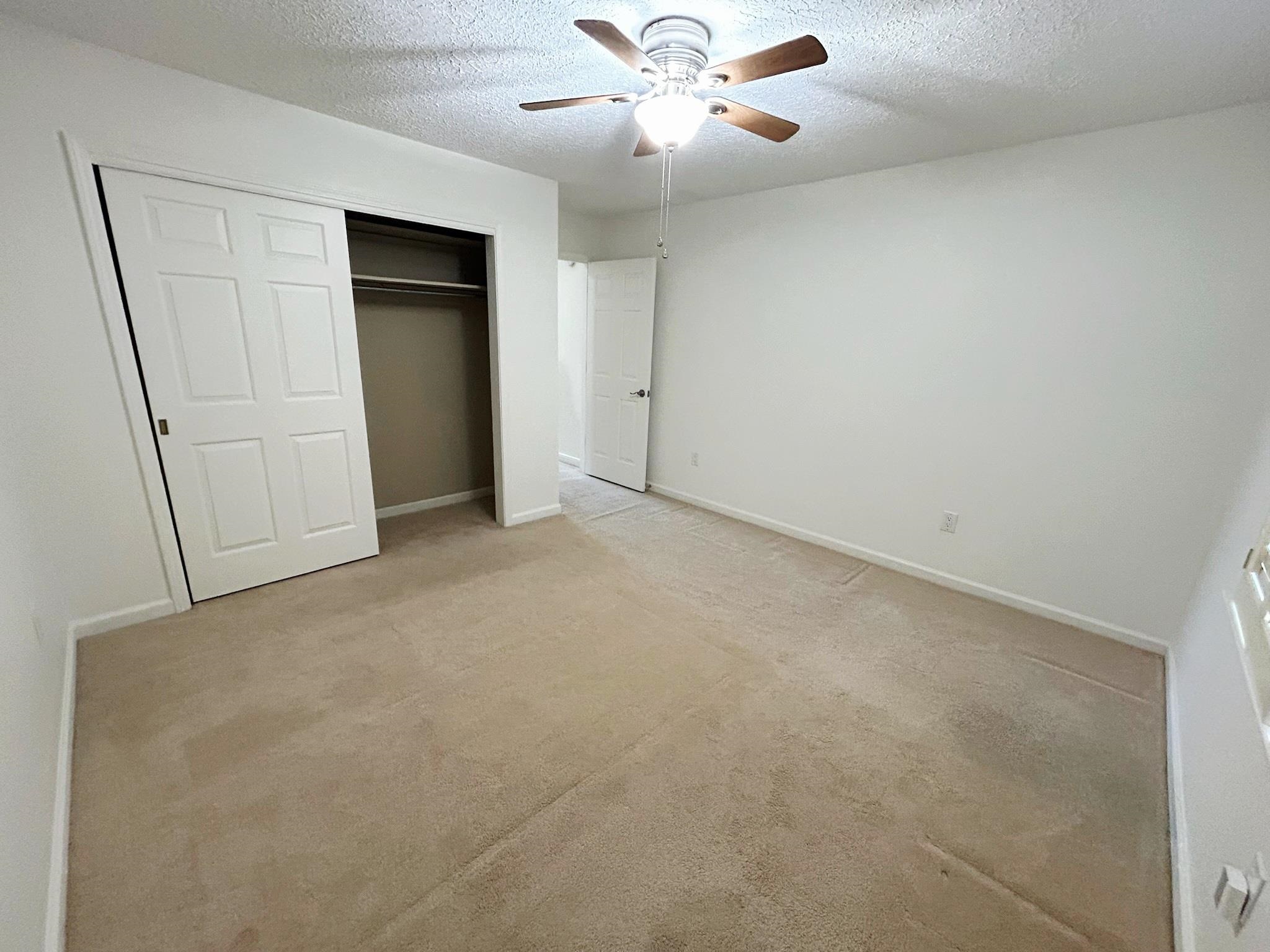 2095 Newfields Road Germantown, TN 38139 - Photo 27 of 34 Unfurnished bedroom with a closet, light carpet, a textured ceiling, and a ceiling fan