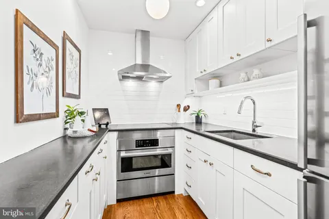 a kitchen with granite countertop stainless steel appliances a sink and cabinets