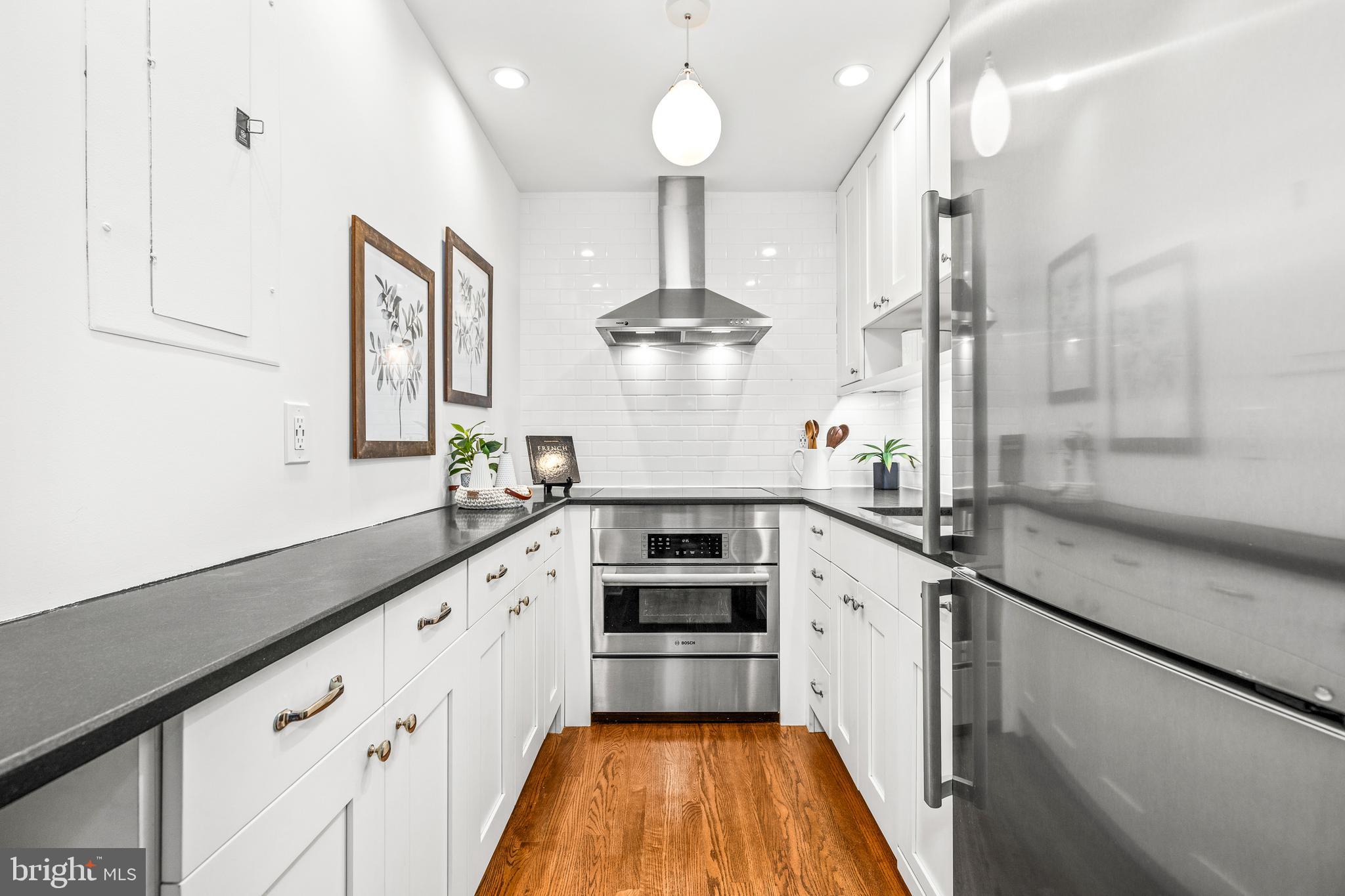 1730 16th Street Northwest, Unit 14 Washington, DC 20009 - Photo 14 of 30 a kitchen with a stove and a chandelier
