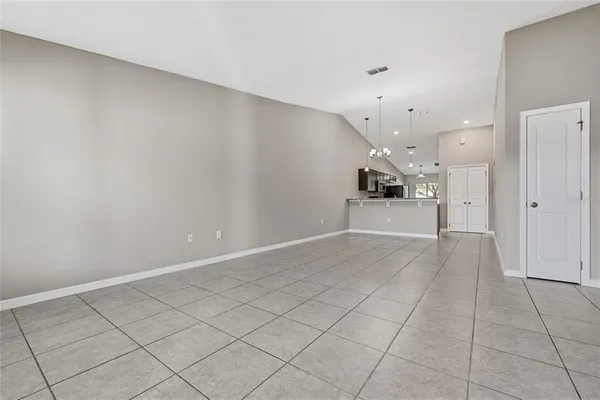 an empty room with kitchen and windows