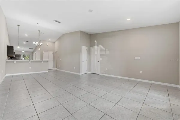 an empty room with kitchen and natural light