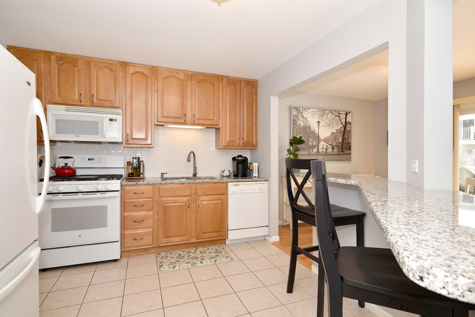 1622 Hadley Court, Unit C1 Wheeling, IL 60090 - Photo 10 of 32 a kitchen with granite countertop cabinets a dining table and chairs