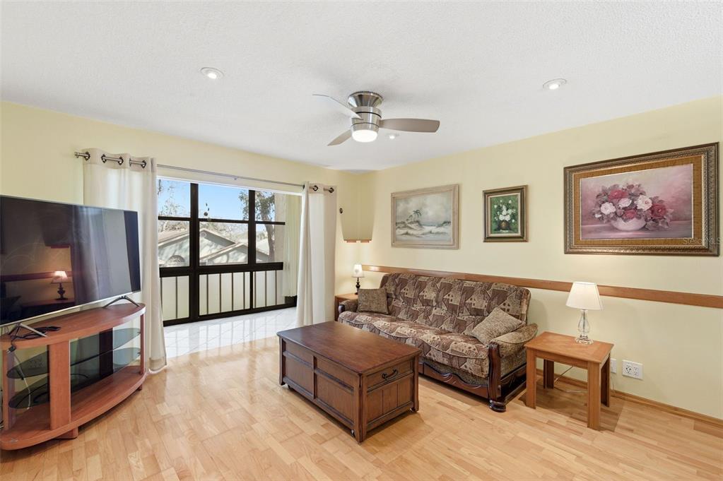 11485 Oakhurst Road, Unit 200208 Largo, FL 33774 - Photo 9 of 25 a living room with furniture and a flat screen tv