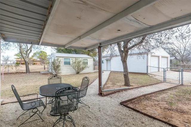 a view of a patio with a table chairs and a backyard